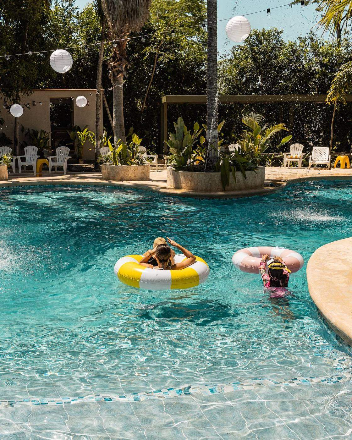 Huéspedes disfrutando la piscina en flotadores durante el día